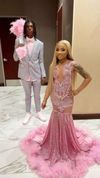 Couple in formal wear, woman in sparkling pink mermaid dress with feathers, man in light gray suit, perfect for ZAPDRESS prom fashion.