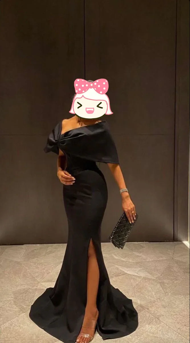Elegant woman in black off-shoulder evening gown with a slit, holding a clutch, ZAPDRESS fashion