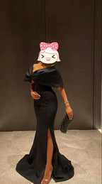 Elegant woman in black off-shoulder evening gown with a slit, holding a clutch, ZAPDRESS fashion