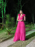 Woman in vibrant pink evening dress standing outdoors by green trees at night, ZAPDRESS fashion