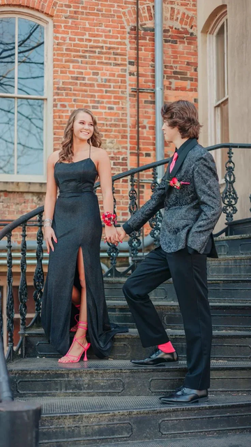 Young couple in formal black attire with pink accents holding hands on outdoor stairs, ZAPDRESS