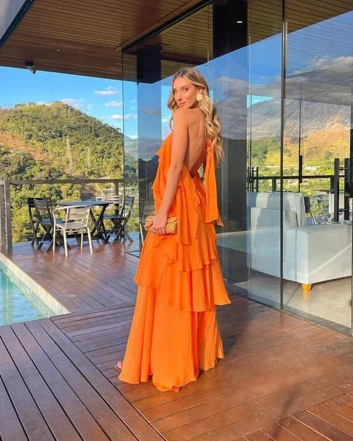 Woman in a bright orange ruffle dress on a wooden deck with mountain views, ZAPDRESS fashion