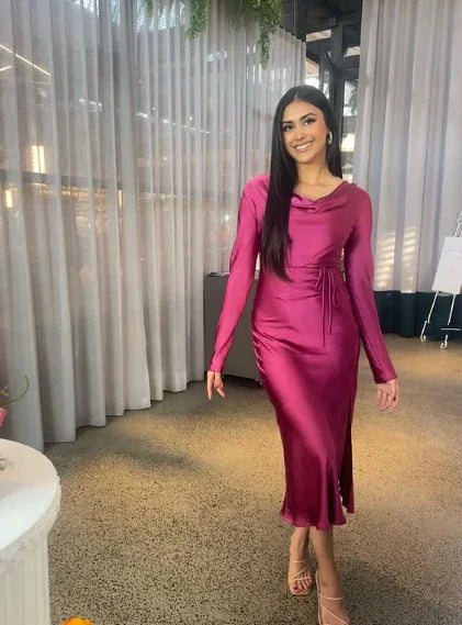 Woman wearing a magenta satin long-sleeve dress from ZAPDRESS, standing indoors