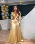 Woman in elegant gold satin cutout dress on yacht, ZAPDRESS style, with gold balloons
