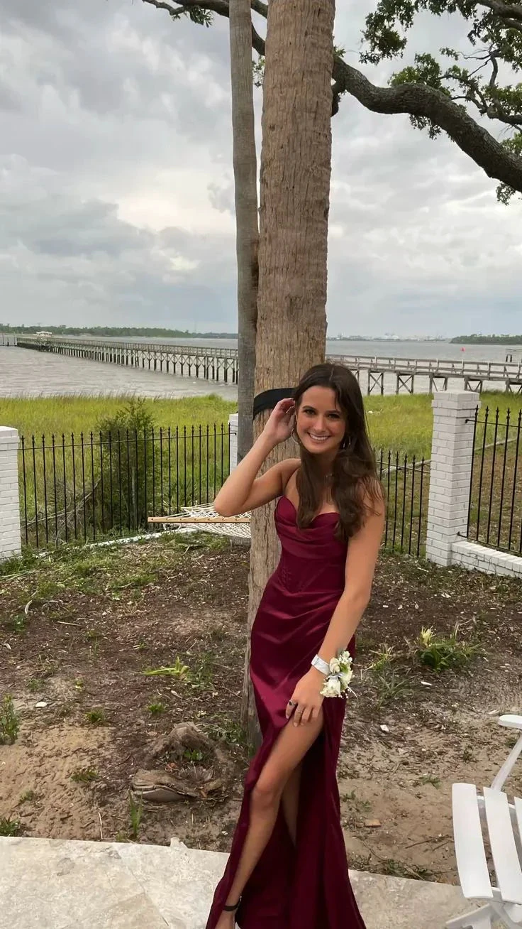 Woman in burgundy formal dress posing outdoors near water, ZAPDRESS fashion