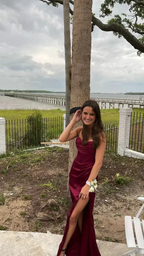 Woman in burgundy formal dress posing outdoors near water, ZAPDRESS fashion