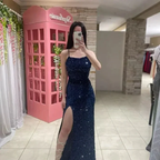 Woman in blue sequin evening dress with high slit at ZAPDRESS boutique, pink backdrop