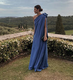 Woman in elegant blue one-shoulder gown outdoors, ZAPDRESS fashion style, garden backdrop