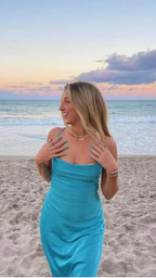 Woman in turquoise dress on sandy beach at sunset, ZAPDRESS fashion.