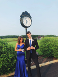 Couple dressed in formal blue attire at Cranberry Highlands golf course near outdoor clock, Zapdress style