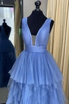 Elegant layered blue tulle gown with deep V-neck on mannequin at ZAPDRESS boutique