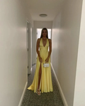 Woman in yellow evening dress with slit holding white purse, ZAPDRESS hallway fashion