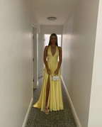 Woman in yellow evening dress with slit holding white purse, ZAPDRESS hallway fashion