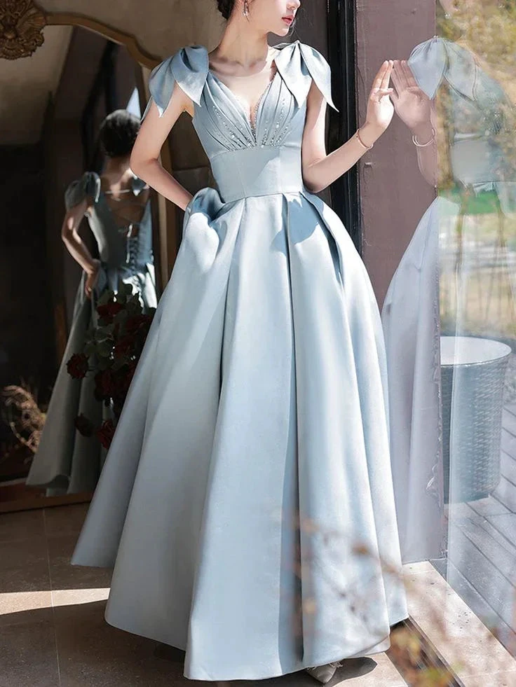 Elegant light blue evening gown with bow sleeves, full skirt, by ZAPDRESS near a window