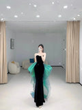 Woman in elegant black evening gown with green tulle detail posing indoors at ZAPDRESS
