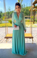 Woman in elegant mint green evening gown holding white clutch in garden, ZAPDRESS fashion