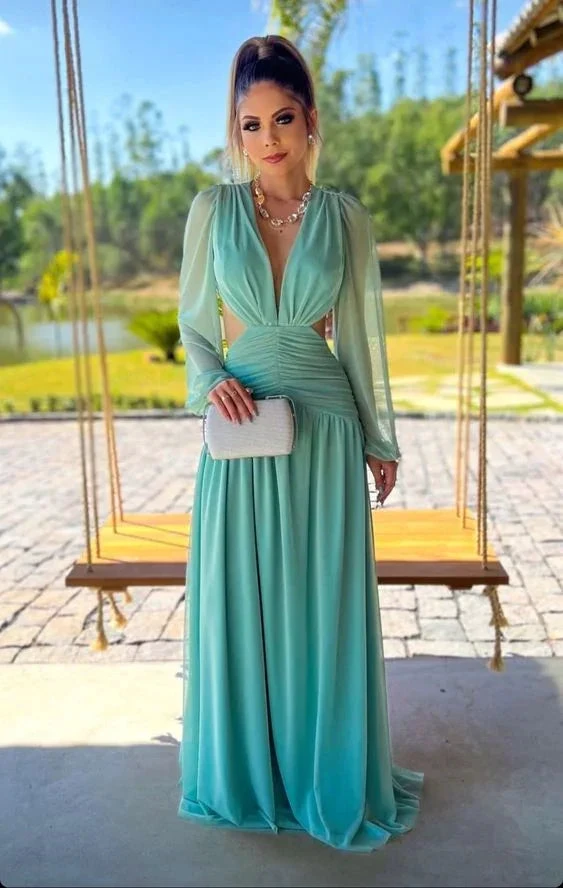 Woman in elegant light blue maxi dress with sheer sleeves, holding clutch, outdoors by a swing