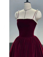 Elegant burgundy velvet dress with pearl trim on bodice, displayed on mannequin at ZAPDRESS