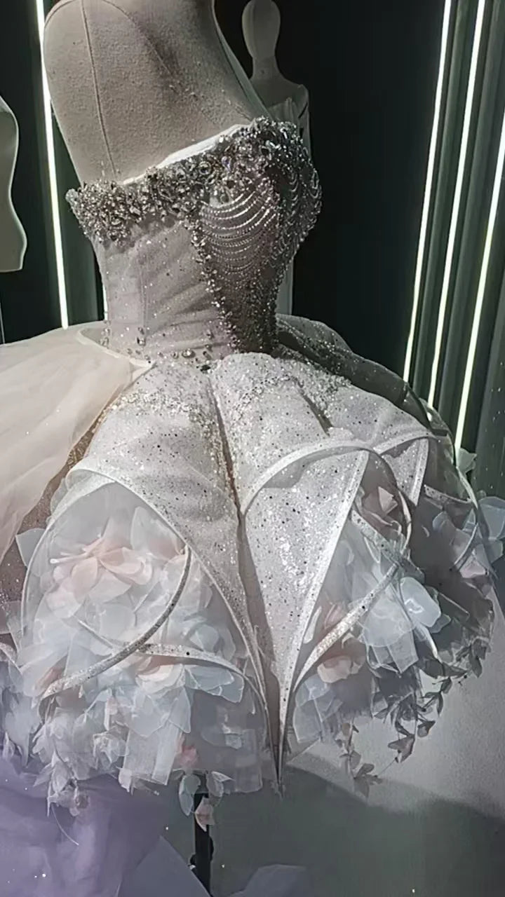 Vestido com botão de flor adornado com cristais e penas em véu estrelado