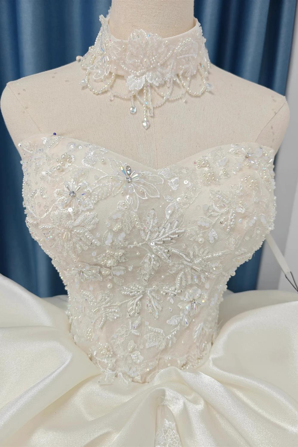 Vestido de fiesta sin tirantes de encaje marfil con cuello gargantilla y falda con lazo