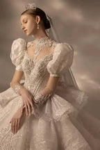 Vestido de novia de tul con cuello alto, mangas abullonadas, bordado de lentejuelas y cola con volantes en capas Q6020