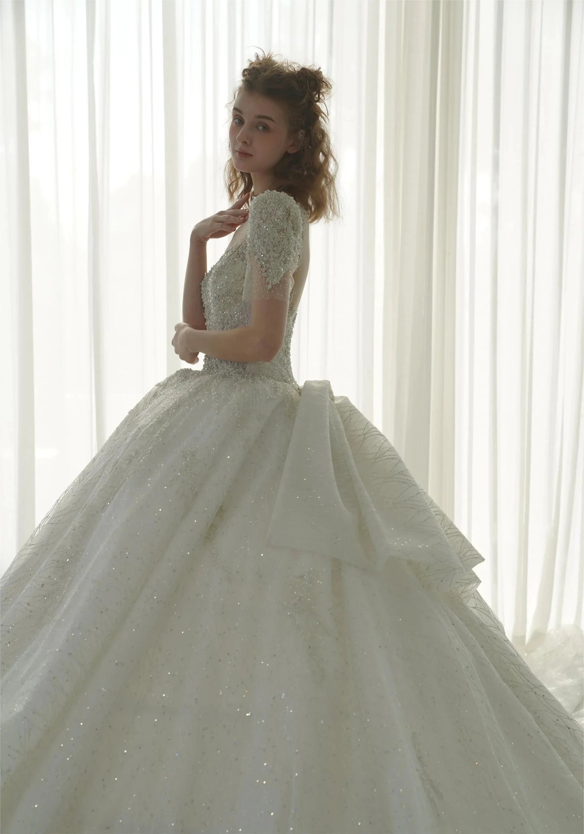 Vestido de Noiva Luminoso com Saia Rodada, Decote Ilusão, Tule, Bordado com Miçangas de Cristal e Cauda com Laço nas Costas Q-6023