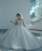 Vestido de novia etéreo con hombros descubiertos, ilusión de encaje, bordado de cuentas y cola catedral M-002