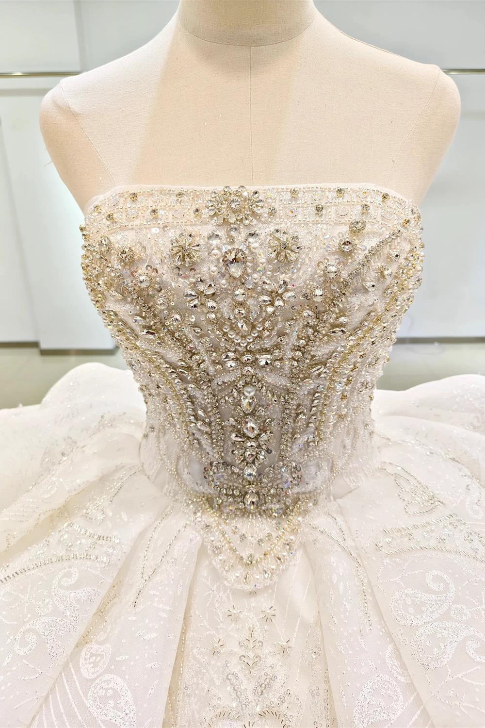 Vestido de fiesta sin tirantes con brillo blanco, busto con cuentas y cola con volantes