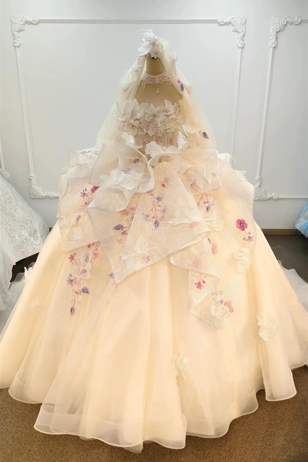 Abito da ballo senza spalline color rosa pesca con gonna ricamata e mantella di tulle floreale