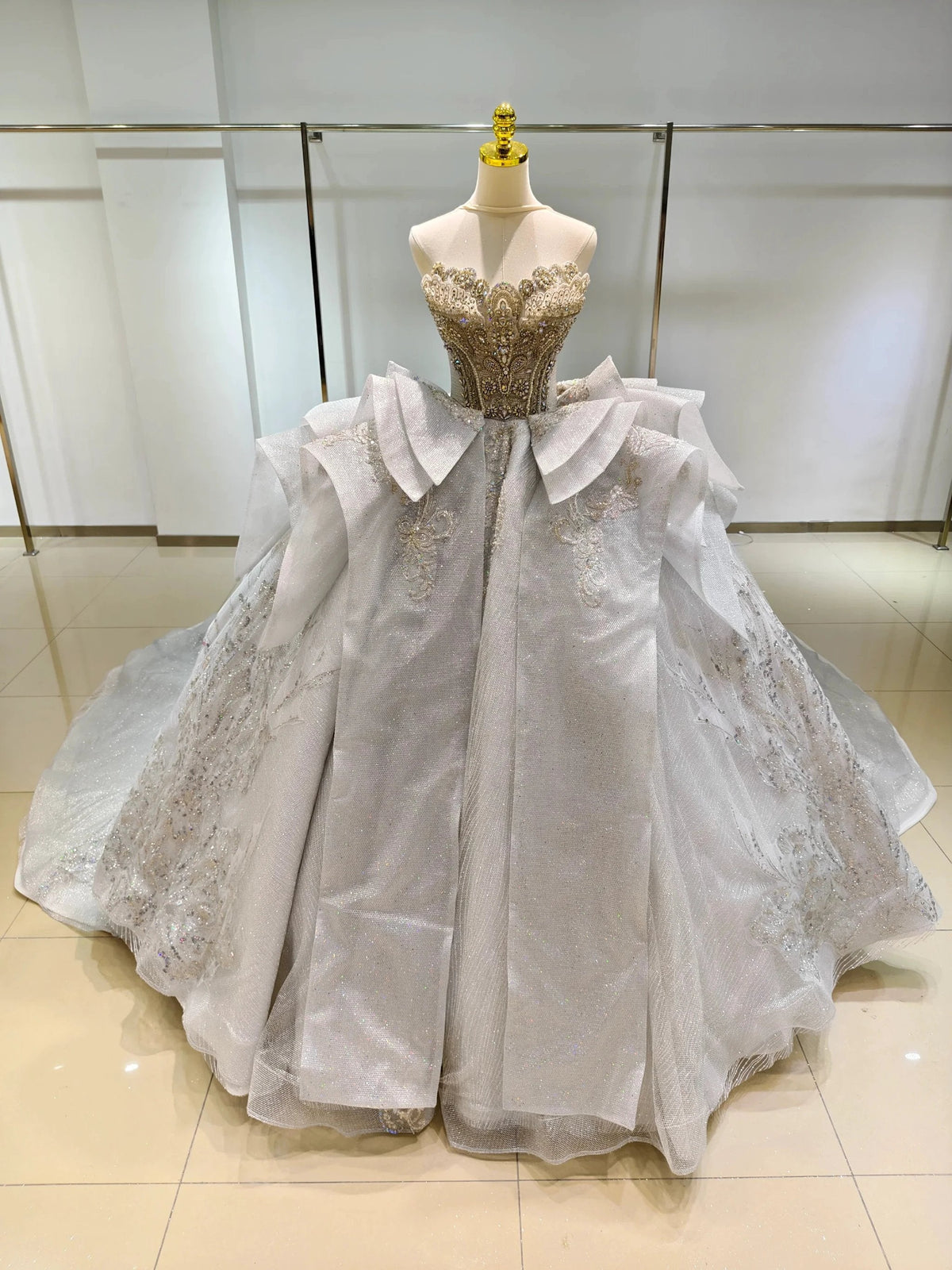 Vestido de gala sin tirantes Silver Haze: busto con cuentas doradas y cola con volantes