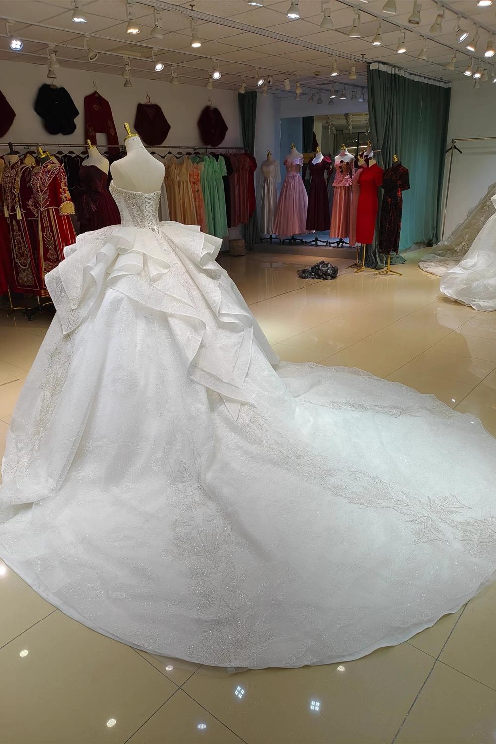 Vestido de fiesta sin tirantes con brillo blanco, busto con cuentas y cola con volantes