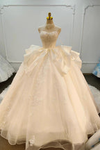 Vestido de fiesta sin tirantes de encaje marfil con cuello gargantilla y falda con lazo