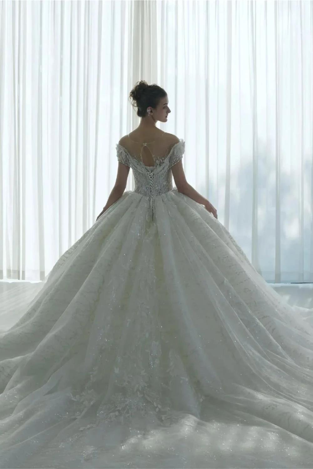Vestido de novia etéreo con hombros descubiertos, ilusión de encaje, bordado de cuentas y cola catedral M-002