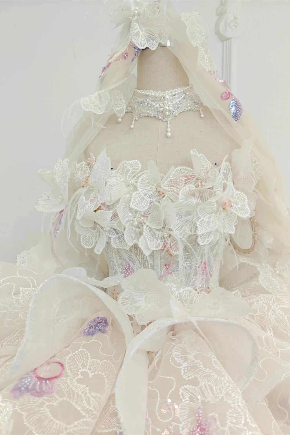 Abito da ballo senza spalline color rosa pesca con gonna ricamata e mantella di tulle floreale