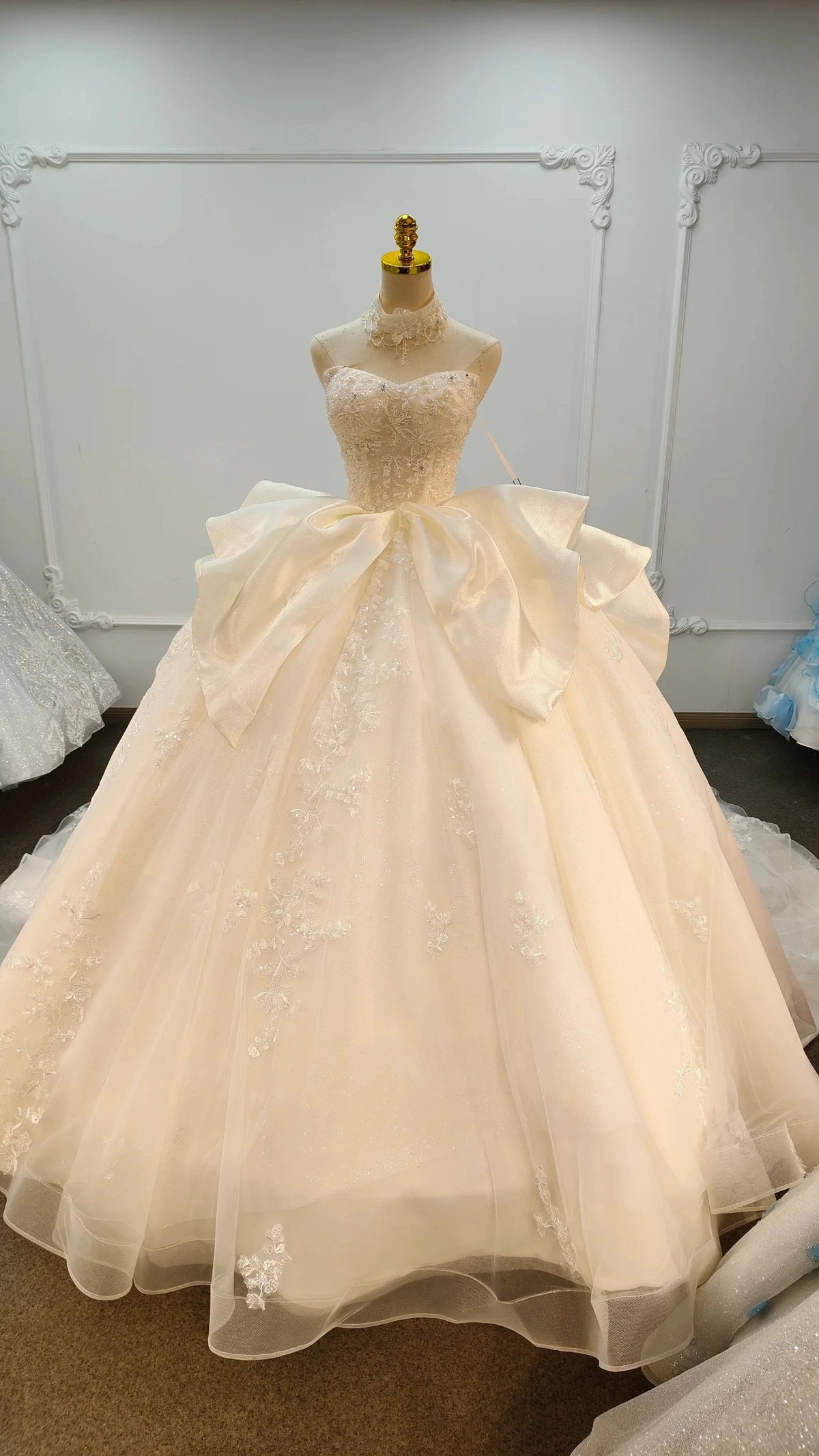 Vestido de fiesta sin tirantes de encaje marfil con cuello gargantilla y falda con lazo