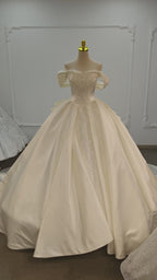 Elfenbeinfarbenes, schulterfreies Ballkleid mit glänzendem Satin, perlenbesticktem Oberteil und Kathedralenschleppe aus Satin